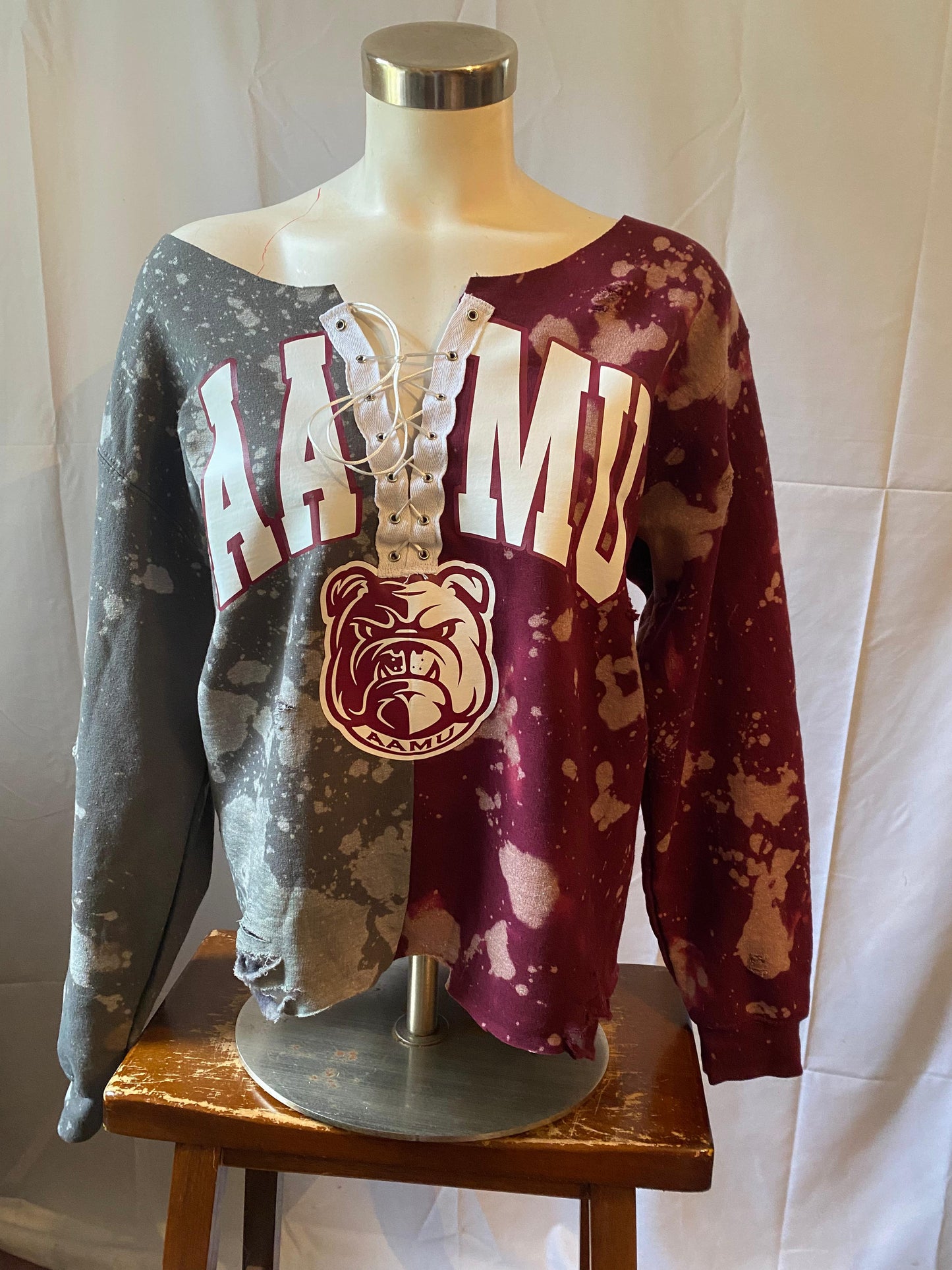 Two distressed sweatshirts on a mannequin with 'HAWAII' and 'BULLDOGS' text against a white background.