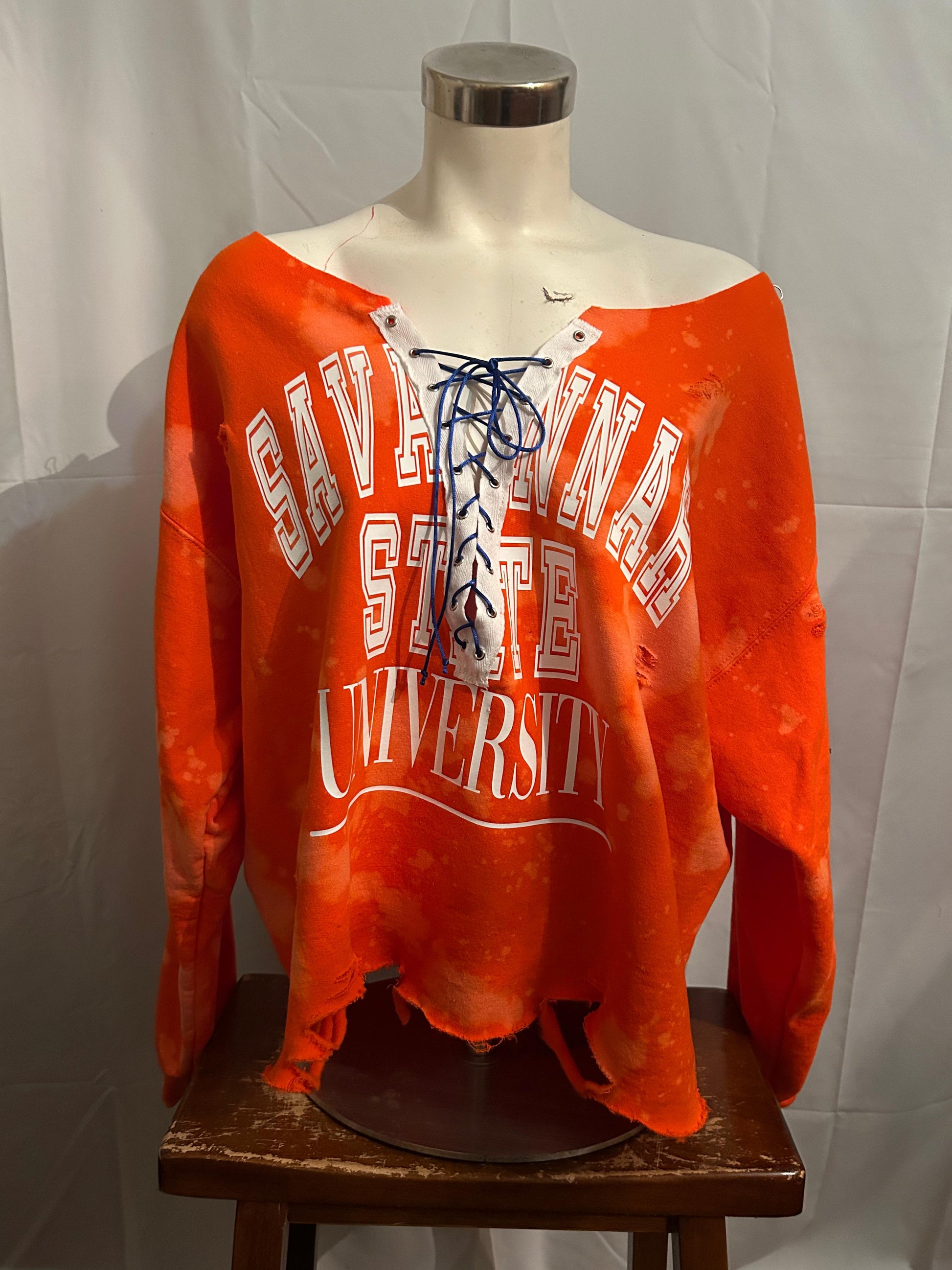 Orange sweatshirt with 'Cavalier State University' text on a mannequin against a white background