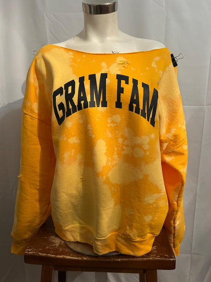 Yellow tie-dye sweatshirt with 'GRAM FAM' text on a mannequin against a white background