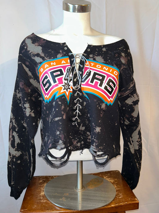 Black distressed long-sleeve top with 'San Antonio Spurs' logo on a mannequin.